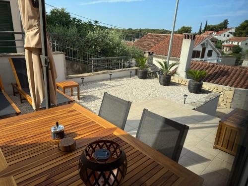 a wooden table and chairs on a patio at Lorenzo apartment in Milna