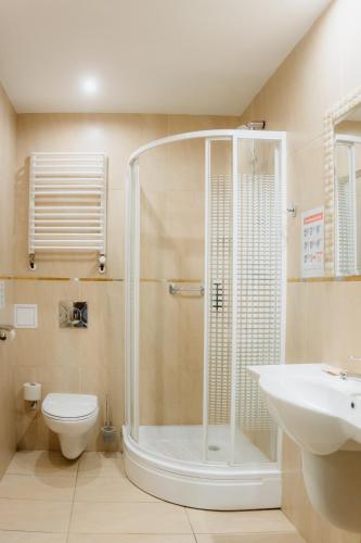 a bathroom with a shower and a toilet and a sink at Sandra Spa Karpacz & Aquapark in Karpacz