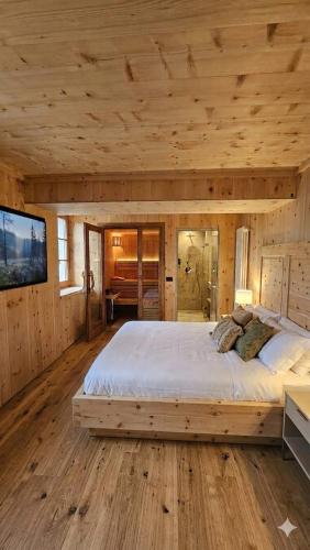 a bedroom with a large bed in a wooden cabin at Rifugio Ghiacciaio dei Forni in Valfurva
