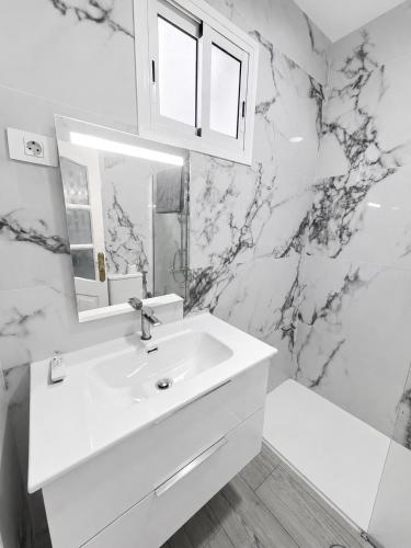 a white bathroom with a sink and a mirror at Noalys Entre Mar y Valle in Agaete