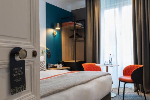 a hotel room with a bed and a table and chairs at Oceania Hôtel d'Anjou Angers in Angers