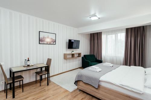 a hotel room with a bed and a desk at Apart Hotel Anastasia in Chişinău