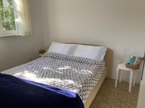 a bedroom with a bed and a table with a window at 20 Koraka in Klenovica