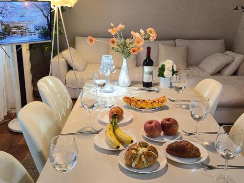a table with plates of food and wine glasses at 스미다 stay in Bucheon