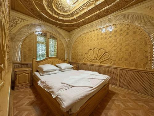 a bedroom with a large bed with a ceiling at Turkiston Hotel in Namangan