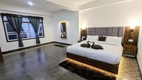 a bedroom with a large bed with two large windows at Urbane Haauz in Pelling