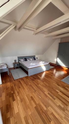 a room with a bed and a wooden floor at Penzion Za plotem in Vranová