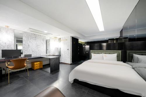 a bedroom with a bed and a desk and a television at Yeoksam Lumiere Hotel in Seoul