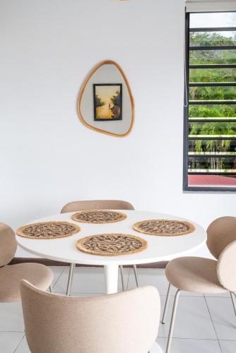 a white table with chairs and a mirror on a wall at Bantaskine Apartments in Paramaribo