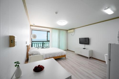 a hotel room with a bed and a television at Wando Love You Pension in Wando