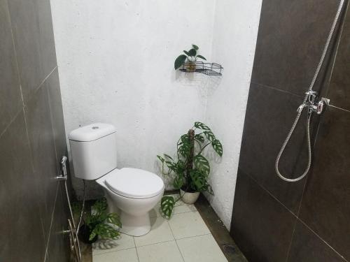 a bathroom with a toilet and plants in it at Le Pandai in Bogor