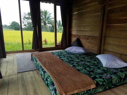 a bedroom with a bed with a view of a field at Le Pandai in Bogor