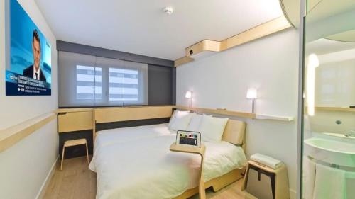 a bedroom with a bed with a laptop on it at Nomad Hotel le Havre Centre Gare in Le Havre