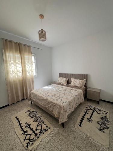 a bedroom with two beds and two rugs at La maison douce Bizerte in Bizerte