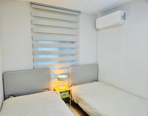 two beds in a small room with a window at 후암가옥 in Seoul