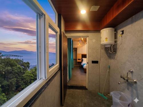 a bathroom with a window and a view of a bedroom at Hotel Oakland Landour in Mussoorie