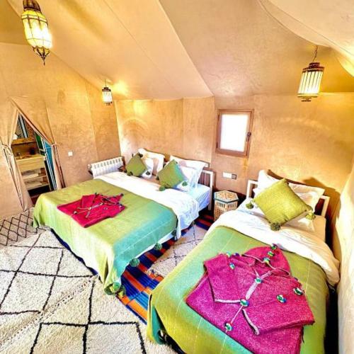 a room with two beds in a small room at Sahara Luxe Camp in Merzouga