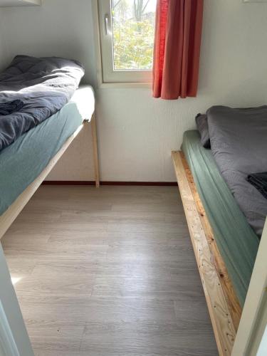 a room with two bunk beds and a window at De huismus in Sleen