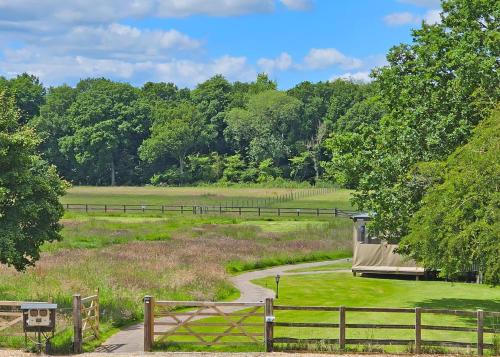 a park with a fence and a field with trees at Hampshire Hills in Bighton