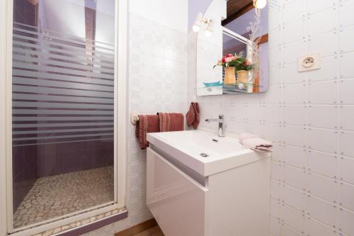 a white bathroom with a sink and a shower at Gîte Nautilus in Elven