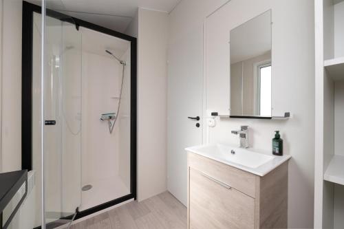 a white bathroom with a sink and a shower at La Brisse d'Erdeven in Erdeven