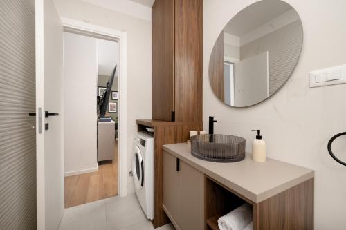 a bathroom with a sink and a mirror at Lejla Garden Apartment in Podstrana