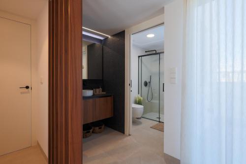 a bathroom with a shower and a toilet and a sink at Designer Villa with BBQ & Heated Pool on Santa Rosalia Lake Resort in Torre-Pacheco