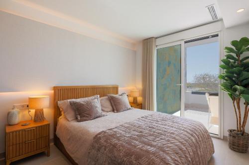 a bedroom with a bed and a large window at Designer Villa with BBQ & Heated Pool on Santa Rosalia Lake Resort in Torre-Pacheco