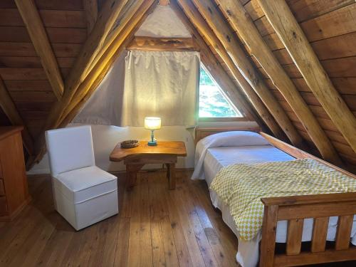a bedroom with a bed and a table and a window at Casa cuidamos in Mar de las Pampas