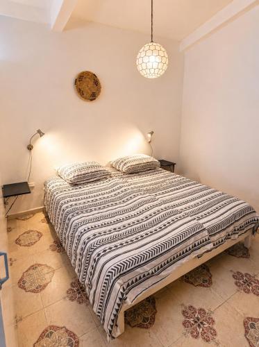 a bedroom with a bed with a black and white comforter at Casa de Hollanda in Sidi Ifni