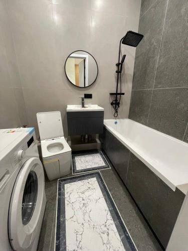 a bathroom with a sink toilet and a mirror at Olympic Park Apartments near Almaty Arena in Almaty