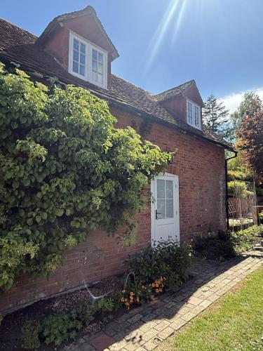 a red brick house with a white door at The Coach House in Halstead