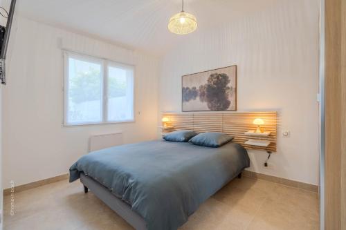 a bedroom with a large bed with two blue pillows at Le Clos de Vaires in Vaires-sur-Marne