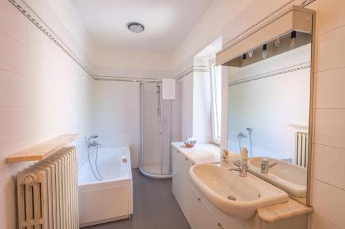 a white bathroom with a sink and a bath tub at Albergo Osteria Leso1815 in Bosco Chiesanuova