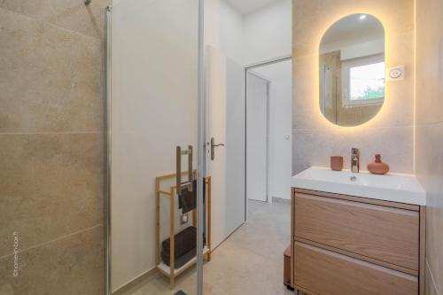 a bathroom with a sink and a mirror at Le Clos de Vaires in Vaires-sur-Marne