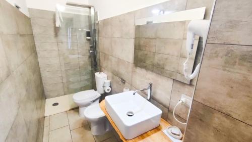 a bathroom with a toilet and a sink and a shower at Il Giardino Del Sole in Agnone Bagni