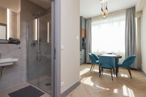 a bathroom with a table and chairs and a shower at SOLWO Suites Berlin Charlottenburg in Berlin