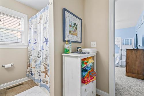 a bedroom with a white cabinet and a shower at 3 BDR, Oceanview's, Walk to Pier in Carolina Beach