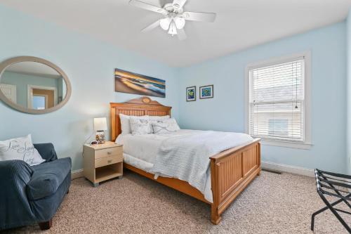a bedroom with a bed and a chair and a mirror at 3 BDR, Oceanview's, Walk to Pier in Carolina Beach