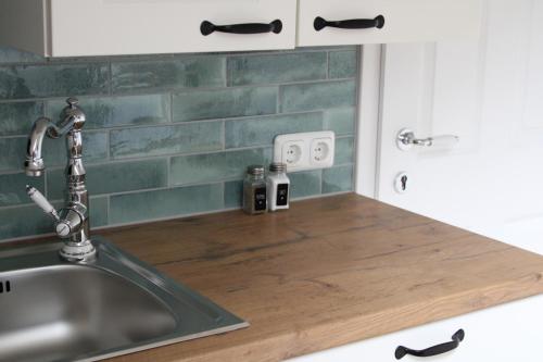 a kitchen sink with a wooden counter top next to it at Ferienwohnung Gaiswinkler in Grundlsee