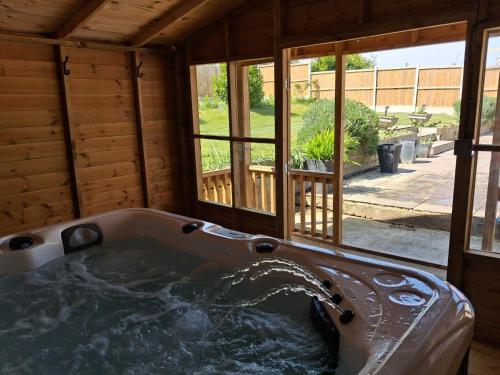 a large tub in a room with a window at Marley Farm Bungalow in Deal