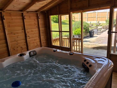 a jacuzzi tub in a house with a window at Marley Farm Bungalow in Deal