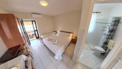 a bedroom with a bed and a shower and a toilet at Peaceful studio in avonija in Murine