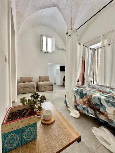 a bedroom with a bed and a couch and a table at Amare Gallipoli in Gallipoli