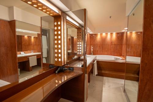 a bathroom with a tub and a large mirror at Four Points by Sheraton Padova in Padova
