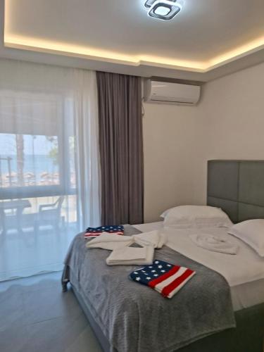 a hotel room with a bed with an american flag towels on it at D&D hotel in Shëngjin