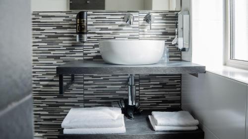 a bathroom with a sink on a counter with towels at Hotel Oepkes in West-Terschelling