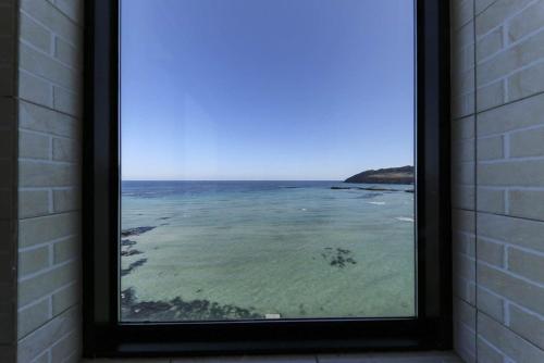 a view of the ocean from a window at Hamduk Pungkyungchae Pension in Jeju