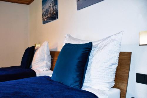 a bedroom with a bed with blue and white pillows at Mountain Lodge Stubai in Neustift im Stubaital