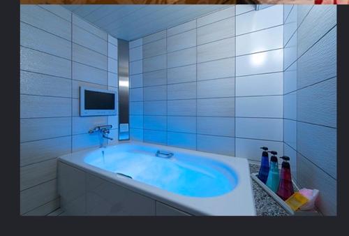 a bathroom with a tub with a tv in it at ホテルヴェローナ in Yokohama